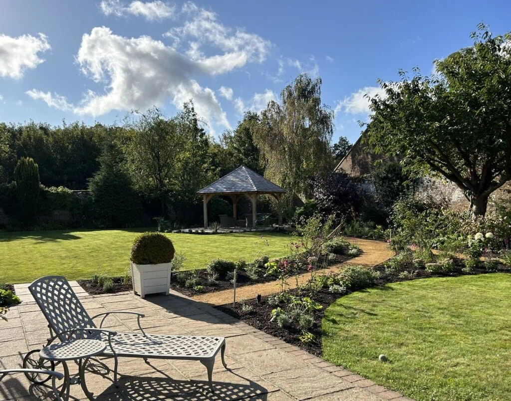 Soft planting flanks a path taking you to the oak framed gazebo